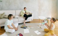 A family enjoying creative activities together in a bright living room setting.